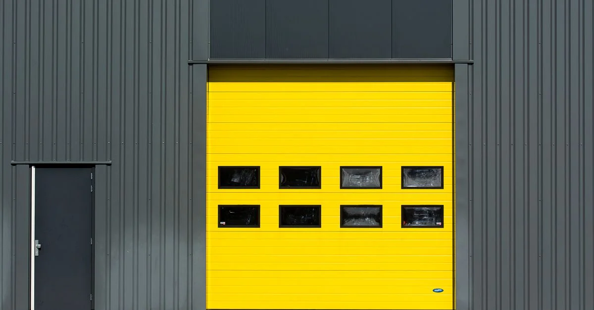 Une structure industrielle élégante avec une porte de garage jaune vif pour un intérêt architectural.