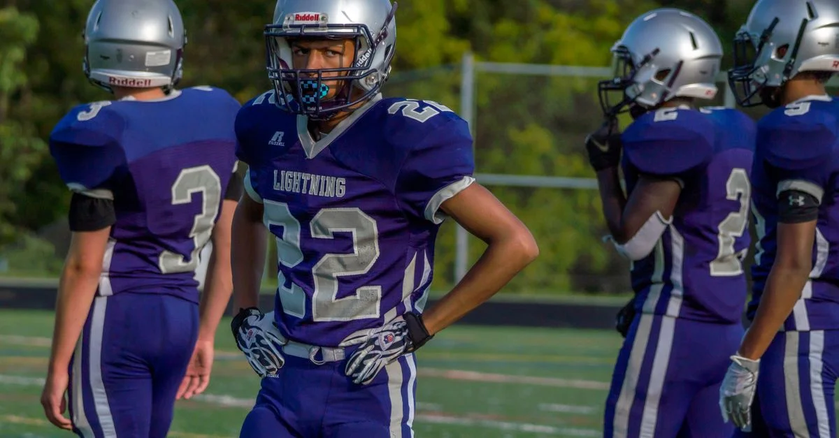 Jeunes athlètes en uniformes de football prêts pour un match en extérieur.