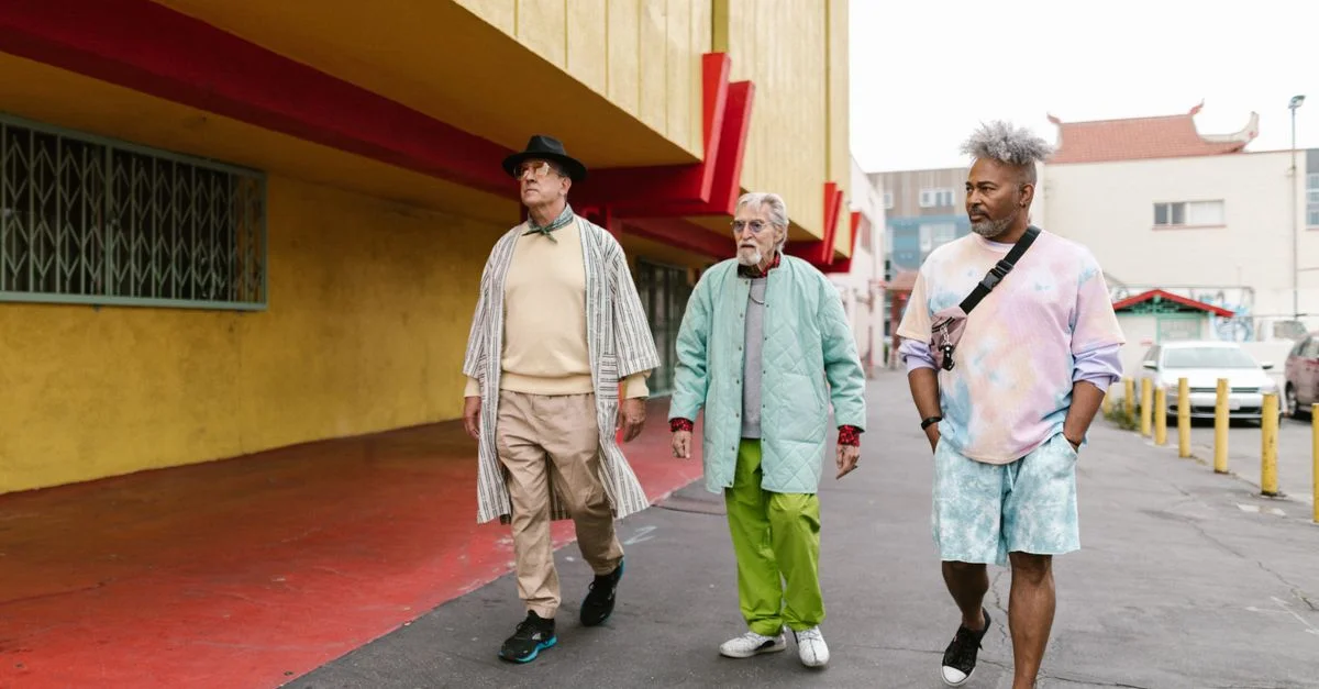 Des hommes âgés affichant un style de rue vibrant tout en marchant sur un trottoir coloré en ville.