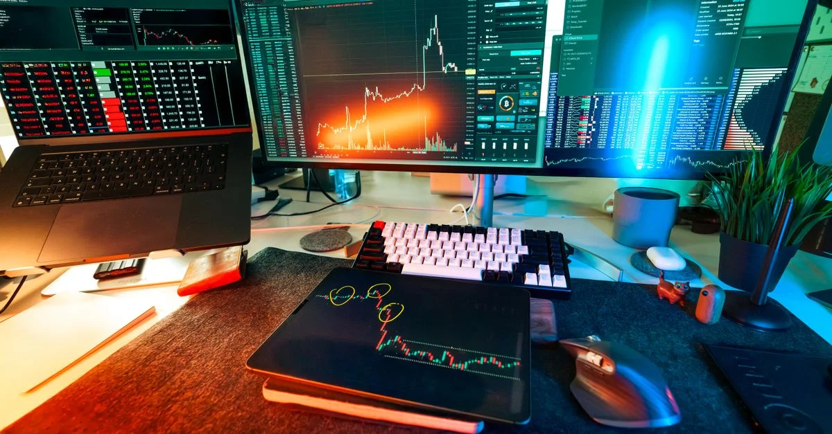 Configuration de trading dynamique avec plusieurs écrans affichant des graphiques de crypto-monnaie et des outils d'analyse de données.